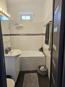 Un baño con bañera, lavabo e inodoro. en Hortensia Apartment, en Tomis Nord