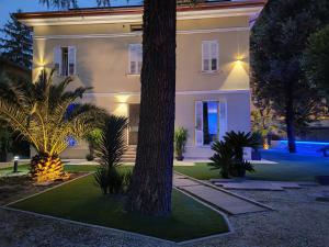 a large white house with a tree in front of it at Villa Primodì in Bologna