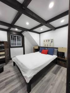 Otter LakeにあるCharming chalet on the lakeのベッドルーム(赤い枕と白い大型ベッド付)
