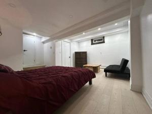 Otter LakeにあるCharming chalet on the lakeのベッドルーム(赤いベッド1台、椅子付)