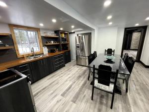 a kitchen and dining room with a table and a refrigerator at Charming chalet on the lake in Otter Lake