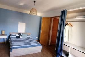 a bedroom with a bed with a blue wall at Les Roses Trémières in Saujon