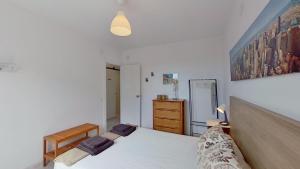 a bedroom with a bed and a dresser and a mirror at Villa Mirador del Mar hostel in Comarruga