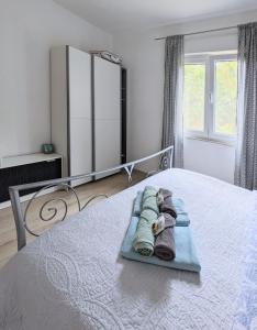 a bedroom with a bed with towels on it at Apartment Sea Garden in Ičići