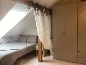 a attic bedroom with a bed and a window at Hygge Home - Bright Cottage-Style Apartment with Terrace & Free Weekend parking in Tartu