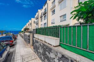un bâtiment avec une clôture verte à côté d'une rue dans l'établissement Beautiful Duplex in Callao Salvaje, à Callao Salvaje