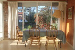 a dining room with a table and chairs and a window at Chalet El Caracol in Pinamar