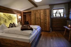 ein Schlafzimmer mit einem Bett in einem Zimmer mit Holzwänden in der Unterkunft Apartments Haus am Anger - Romantik-Beauty-Wellness in Jungholz