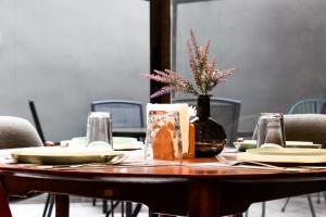 a wooden table with plates and a vase with flowers on it at Lujoso Depto con Espectacular terraza a unos pasos del Angel in Mexico City +79 photos
