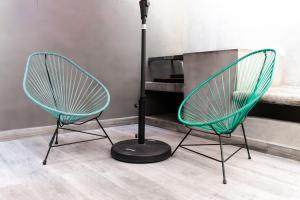 two green chairs and a lamp in a room at Lujoso Depto con Espectacular terraza a unos pasos del Angel in Mexico City