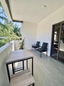a patio with two chairs and a table on a balcony at Sunset Views 3-Bedroom Apt, 1min Walk to Beach - NYHA1 in Flic-en-Flac