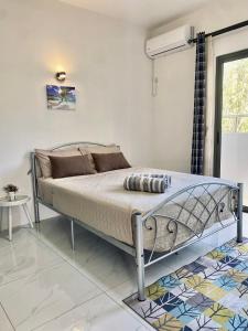 a bedroom with a bed in a room with a window at Sunset Views 3-Bedroom Apt, 1min Walk to Beach - NYHA1 in Flic-en-Flac