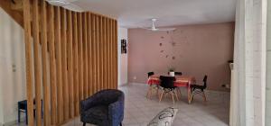 Un comedor con una mesa y sillas y un reloj. en hébergement Les Abymes, en Les Abymes
