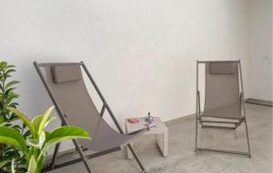 zwei Stühle und ein Tisch mit Spiegel in der Unterkunft Amazing Apartment In Marina Di Modica in Marina di Modica + 10 Fotos