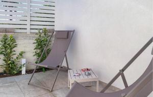 einen Stuhl und einen Tisch neben einer Wand in der Unterkunft Amazing Apartment In Marina Di Modica in Marina di Modica