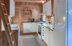 una cucina con mobili bianchi e un frigorifero di Lovely Home In Bjorli With Wifi a Bjorli Altre 16 foto