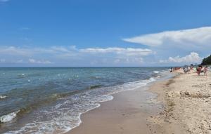 eine Gruppe von Menschen an einem Strand in der Nähe des Wassers in der Unterkunft 1 Bedroom Awesome Apartment In Darlowko in Darłówko