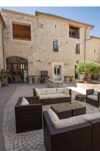 a patio with couches and tables in front of a building at L'Escampe in Saturargues