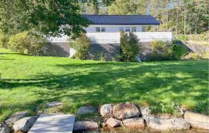 a large yard with a house in the background at 2 Bedroom Gorgeous Home In Vegårshei in Vegårshei +13 photos