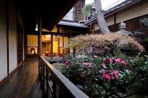 a balcony with pink flowers on a building at Show-an Machiya Inn in Kyoto