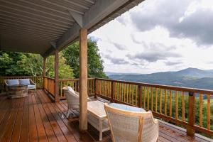 a wooden deck with chairs and a table on it at Grandview Haven in Banner Elk