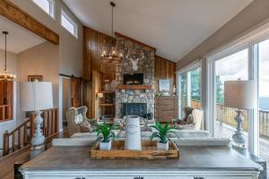 a living room with a stone fireplace and a table at Grandview Haven in Banner Elk