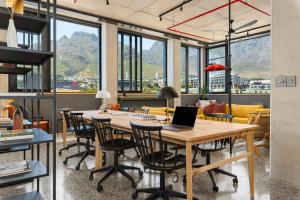 an office with a table and chairs with a laptop on it at Neighbourgood 84 Harrington in Cape Town +31 photos