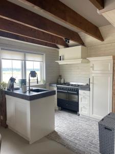 a kitchen with a sink and a stove at Holiday home in Arriën