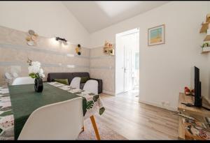 a dining room with a green table and white chairs at Appartement 2pièces paris Disney in Vaires-sur-Marne