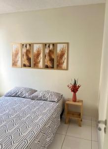 una camera con un letto e quattro quadri appesi al muro di Apartamento 108 a Caruaru