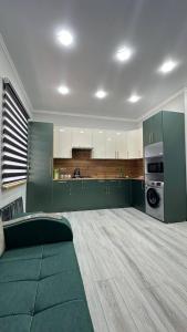 a large kitchen with green cabinets and a green couch at Safo Guest House in Khiva