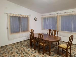a dining room with a wooden table and chairs at Casa Dani in Sibişel