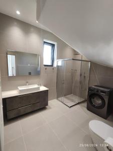 a bathroom with a shower and a sink and a washing machine at Arillas Villas dinos in Arillas