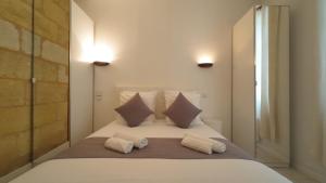 a bedroom with a large white bed with two pillows at Escapade aux Chartrons in Bordeaux