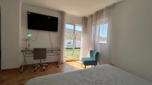 una camera da letto con un letto, una scrivania e una televisione di Piso con gran terraza en malaga arenas ad Arenas