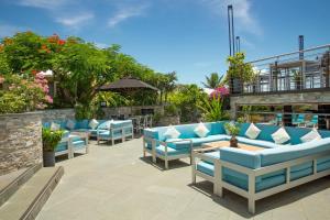 Kokomo Botanical Resort - Caribbean Family Cottages في ترتل كوف: فناء به أرائك وطاولات زرقاء +61 صورة