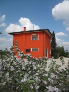 una casa naranja con flores delante en Corte Dante, en Taglio di Po