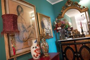 a room with a painting and a vase and a mirror at Fiordiloto B&B 4 STARS in Alba