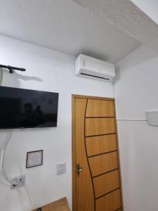 a room with a door and a television on the wall at Studio fantástico in São Paulo