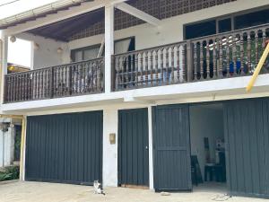 バイーア・ソラノにあるApartaloft en bahia solanoのバルコニーのある家の前に座っている猫