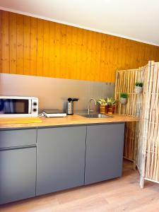 uma cozinha com pia e micro-ondas em Bungalow Bétula - Pichoses Camping - Gerês em Rio Caldo mais 4 fotografias