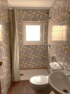 a bathroom with a toilet and a sink and a window at L57 - Habitaciones en Órgiva in Órgiva
