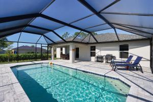 a large swimming pool with a large glass roof at New Build Pool Home With Modern Design and Open Floor Plan in Cape Coral in North Fort Myers