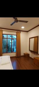 a bedroom with a bed and a mirror and a television at Oibeach in Maamigili