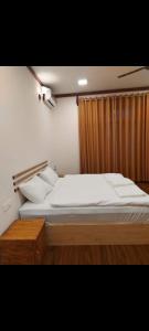 a bedroom with a large bed and a curtain at Oibeach in Maamigili