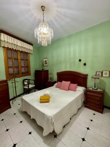 a bedroom with a large bed and a chandelier at Casa Loli y Las in Agaete