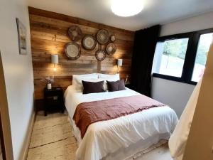 ein Schlafzimmer mit einem Bett mit Uhren an der Wand in der Unterkunft Chalets De La Grande Ourse - Sublime Chalet 16 personnes avec sauna & Jacuzzi ! MAE-8951 in La Plagne Tarentaise
