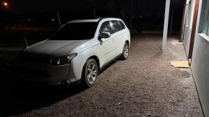 a white car parked in a parking lot at night at Kitnet localizado 6 min shopping in Tubarão