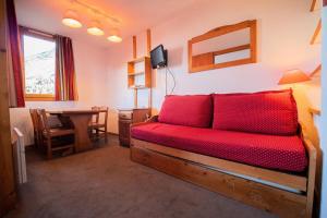 une chambre avec un lit rouge et une salle à manger dans l'établissement Résidence Portail G - PORTAIL 73 MAE-5911, à Valmorel