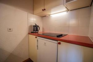 Il comprend une petite cuisine équipée d'une cuisinière et d'un comptoir. dans l'établissement Résidence Portail G - PORTAIL 73 MAE-5911, à Valmorel 7 autres photos